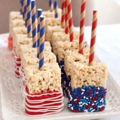 rice krispy treats are arranged in rows on a plate with red, white and blue straws