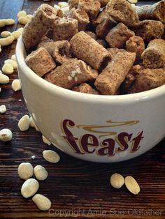 a bowl filled with cereal sitting on top of a wooden table next to some nuts