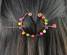 a close up of a person with long hair wearing a headband made out of beads