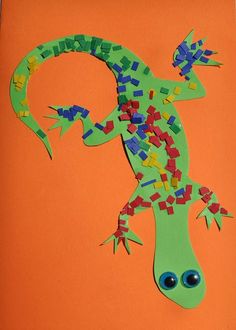 a paper cut out of a lizard on an orange background with blue eyes and green body