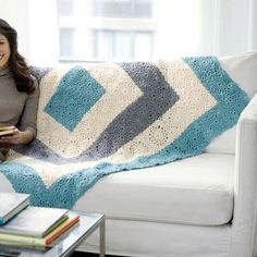 a woman sitting on a couch holding a book