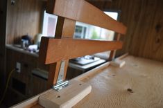 a close up of a wooden bench in a room with wood paneling on the walls