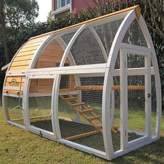 a large white chicken coop sitting in the grass