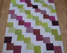 a patchwork quilt sitting on top of a wooden floor