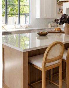 a kitchen island with two chairs next to it