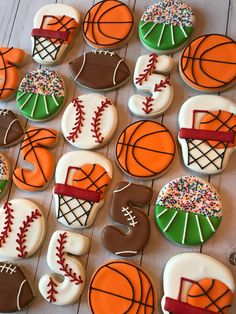 decorated cookies in the shape of sports balls and basketballs are arranged on a table