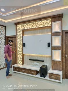 a man standing in front of a wall mounted tv