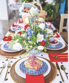 the table is set with plates, silverware and red white and blue napkins