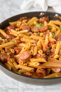 a skillet filled with pasta and sausage