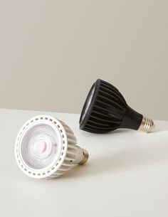 two different types of light bulbs on a white surface