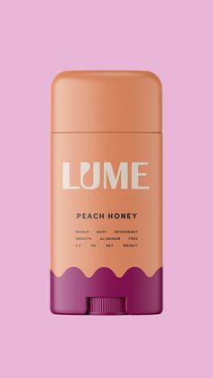 a can of lume peach honey deodorant on a pink background