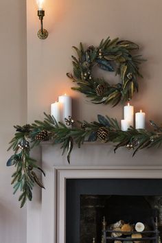 a mantle with candles and wreaths on it