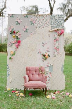 a pink chair sitting in front of a wall covered in flowers and fabric with the words,