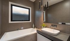 a bathroom with a tub, sink and large mirror