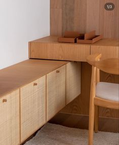 a wooden desk with drawers and a chair next to it on a carpeted floor