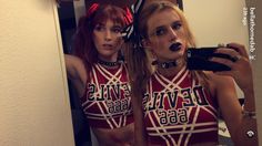 two women in cheerleader outfits taking a selfie