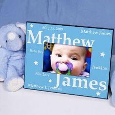 a blue frame with a baby's name and a teddy bear next to it