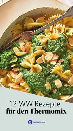 a bowl filled with pasta covered in pesto and almonds