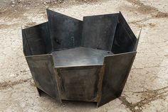 a large metal object sitting on top of a dirt field