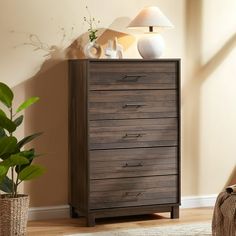 a wooden dresser sitting on top of a hard wood floor next to a potted plant