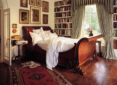 a bed in a room with lots of books on the shelves