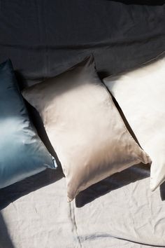 three pillows sitting on top of a bed next to each other