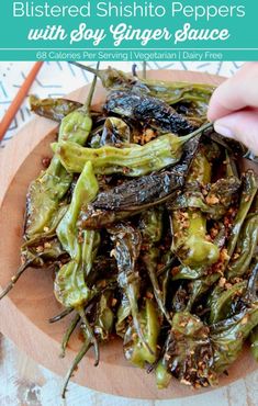 a plate filled with cooked green peppers on top of a wooden cutting board