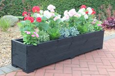 a black planter filled with lots of flowers