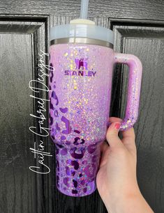 a person is holding up a pink and purple glitter tumbler with the word shine on it