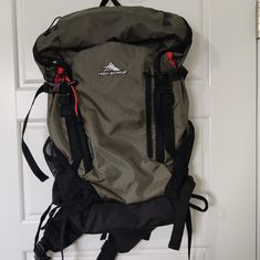 a backpack is hanging on the door with straps attached to it's front pocket