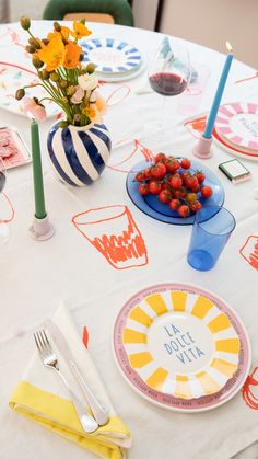 a white table topped with plates and bowls filled with fruit