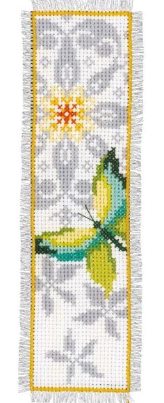 a cross stitched wall hanging with a yellow and green butterfly on it's side