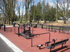 an empty park with benches, bars and other equipment on the side of the road