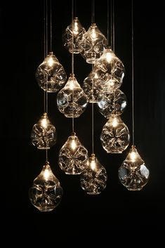 a chandelier made out of glass hanging from strings with lights in the middle