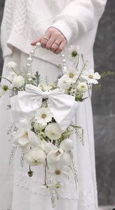 a woman in white holding a bouquet of flowers