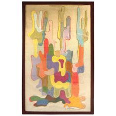 an abstract painting with multiple colors and shapes on white paper, framed in brown wood frame