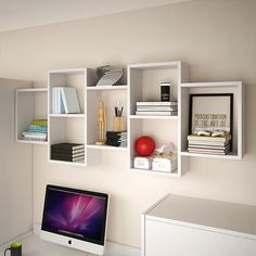 a laptop computer sitting on top of a desk next to a white shelf filled with books