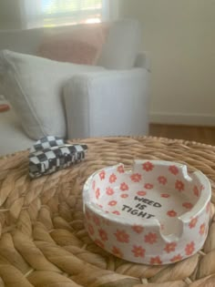 a dog bowl sitting on top of a wicker table next to a white couch