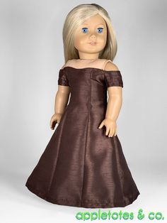 a doll with blonde hair wearing a brown dress and blue eyes, standing in front of a white background