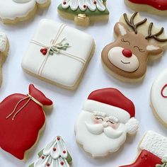 decorated christmas cookies are arranged on a white surface