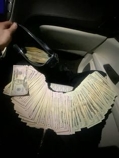 a woman is holding money in her car