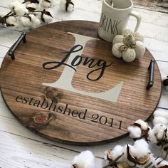 a round wooden sign that says long established 2011 with cotton floss next to it