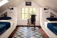 two beds in a room with white walls and blue blankets on top of the beds