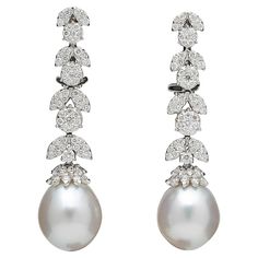 An elegant pair of pearl and diamond dangle earrings. 1.50 carats of white round brilliant cut diamonds set into round and marquise shapes with a pearl drop. 18k white gold Approximately 1.6 inches long A timeless pair of earrings! White Diamond Pearl, Pearl Earrings Long, White Gold Drop Earrings, Diamond Cluster Earrings, White Pearl Earring, Fancy Earrings, Pearl And Diamond Earrings, Diamond Dangle Earrings, Diamond Chain