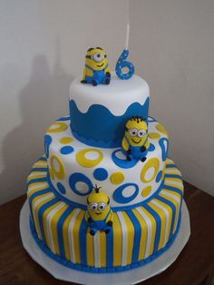 a three tiered cake with minion decorations on it's top and bottom