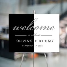 a welcome sign is displayed in front of a storefront window with the words welcome to celebrate