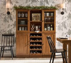 a dining room table with two chairs and a hutch filled with wine glasses on it