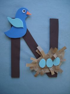 a blue bird sitting on top of a piece of paper next to an egg in a nest