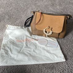 See By Chloe Joan Shoulder Bag In Coconut Brown Dust Bag, Hanging Tag, And Registration Card Included (Will Be In Interior Zip Pocket When Shipped) Zip Top, Interior Zip Pocket And Two Slip Pockets Functional Front Flap Pocket Short Brown Detachable Top Strap And Black Long Crossbody Strap This Bag Is In Great Condition I��’ve Only Used It A Couple Of Times And It Has Been Stored In Its Dust Bag See By Chloe Joan, Chloe Bags, See By Chloe, Shorts With Pockets, Zip Top, Flap Pocket, Crossbody Strap, Black And Brown, Zip Pockets