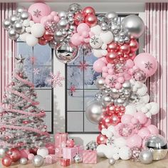 a christmas tree surrounded by pink and silver balloons